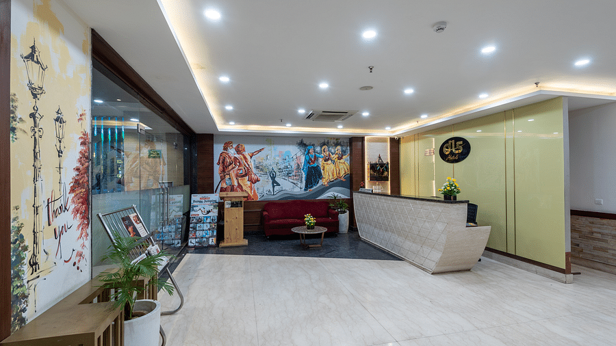 Reception area with a newspaper stand, spiritual wall paintings, and a front desk at DLS The Classio